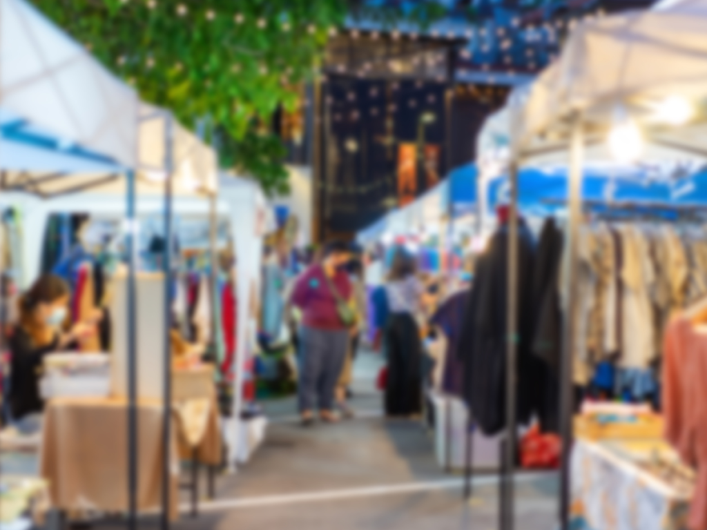 An outdoor community event with multiple tables and tents.