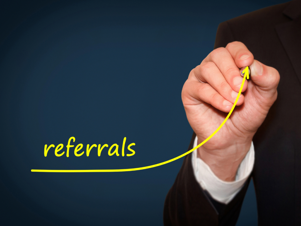 A hand writing out referrals. 