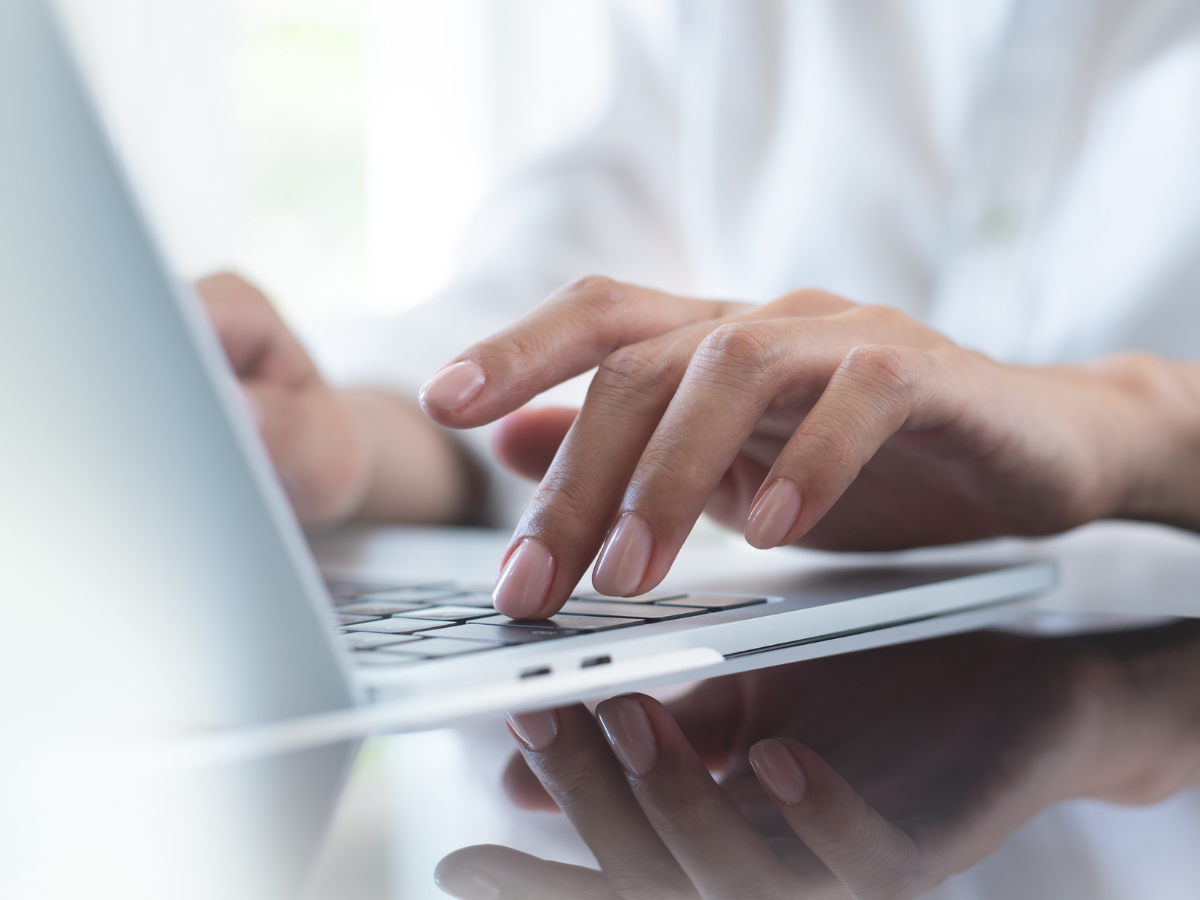 A close-up of hands typing on a laptop keyboard, representing content creation, digital writing, and SEO-focused editing or blog review work.