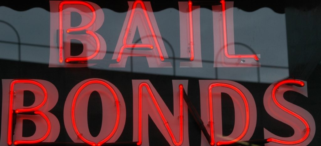 neon light sign in window reading bail bonds